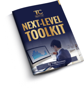 A business booklet titled "Next-Level Toolkit" by Tom Rooney, featuring a man analyzing a bar graph on a computer screen.